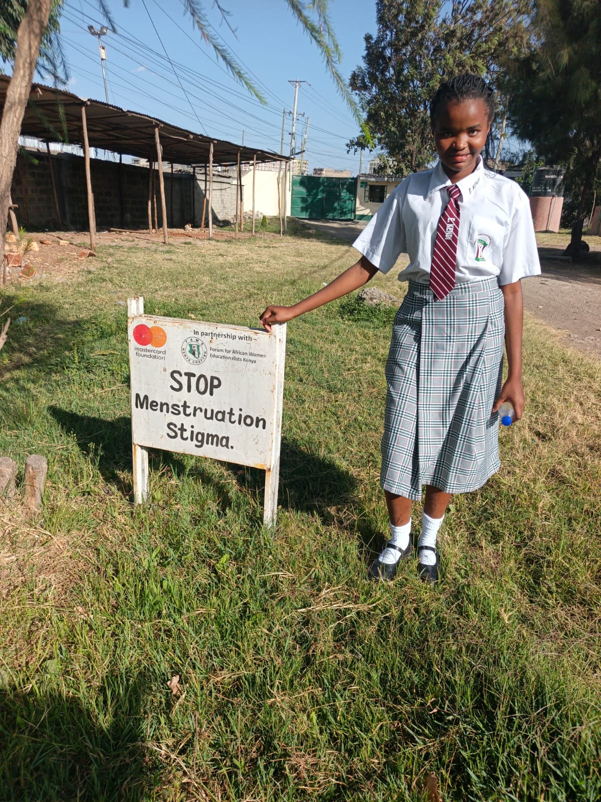 Student beside Stop Menstruation Stigma sign