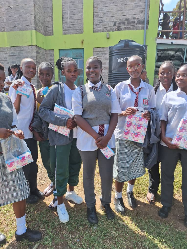 Students holding sanitary product supplies